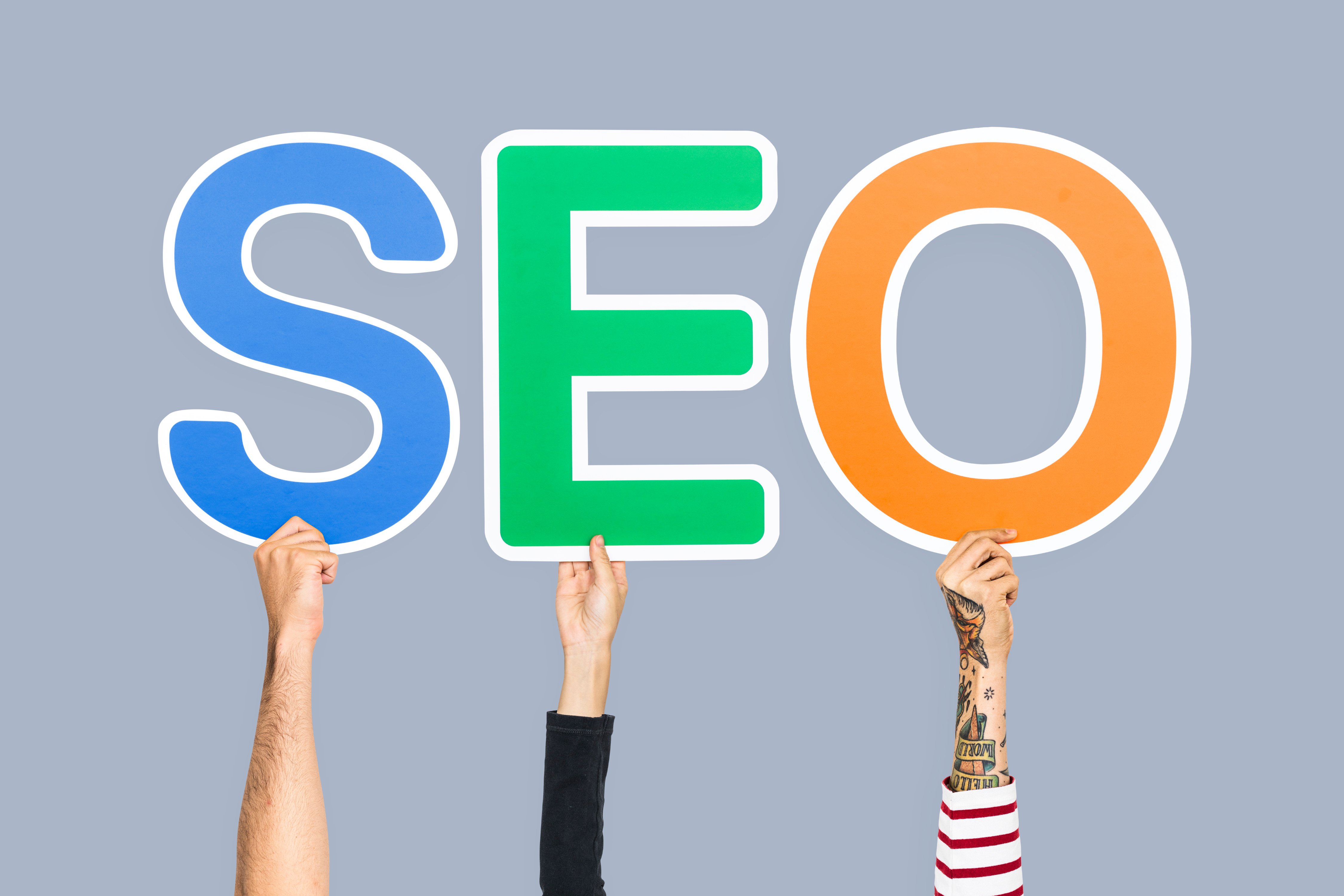 Manos sosteniendo letras formando la abreviatura SEO.