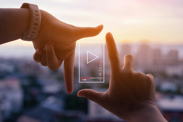 Encuadre de manos e icono de video mostrando un video creado con inteligencia artificial